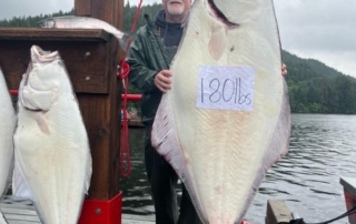 Fishing for Halibut Alaska: A happy anglers stands next to two large halibut caught near Craig, Alaska.
